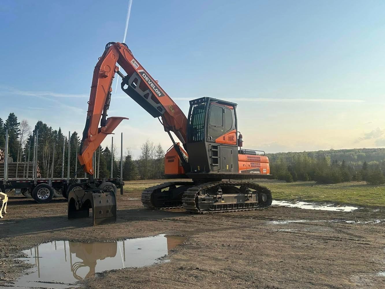 Develon DX225 excavator with grapple at forestry site